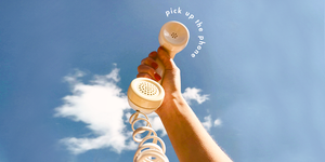 a phone held to the blue sky with the text "pick up the phone"