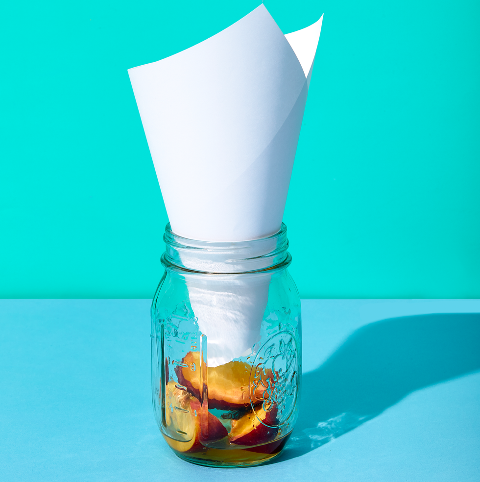 how to kill fruit flies, mason jar with cone shaped paper inside and rotting fruit at the bottom