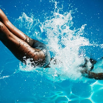 a woman diving into to a swimming pool