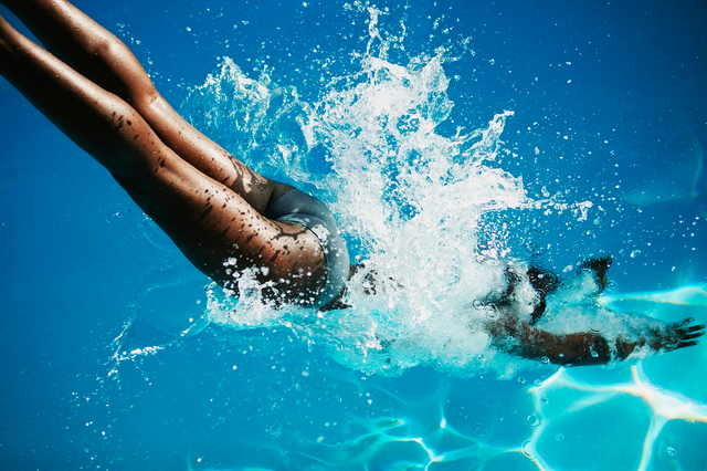 a woman diving into to a swimming pool