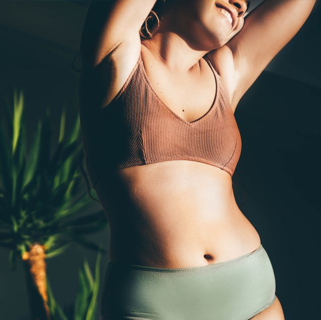 young woman in underwear smiling in natural light