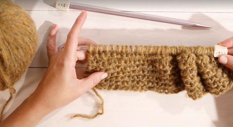 how to knit a scarf for beginners, woman knitting using a knitting needle and yarn