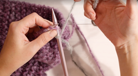how to knit a scarf for beginners, woman knitting a scarf with her yarn and knitting needle