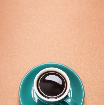 a cup of espresso in a teal cup and saucer
