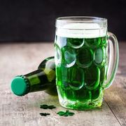 pint of green beer with bottle of beer on side