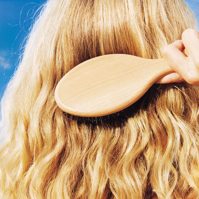 woman brushing her long blonde hair