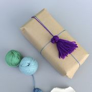 how to make yarn tassel, purple tassel on wrapped brown gift