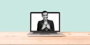 a laptop with a woman looking happy in a blazer