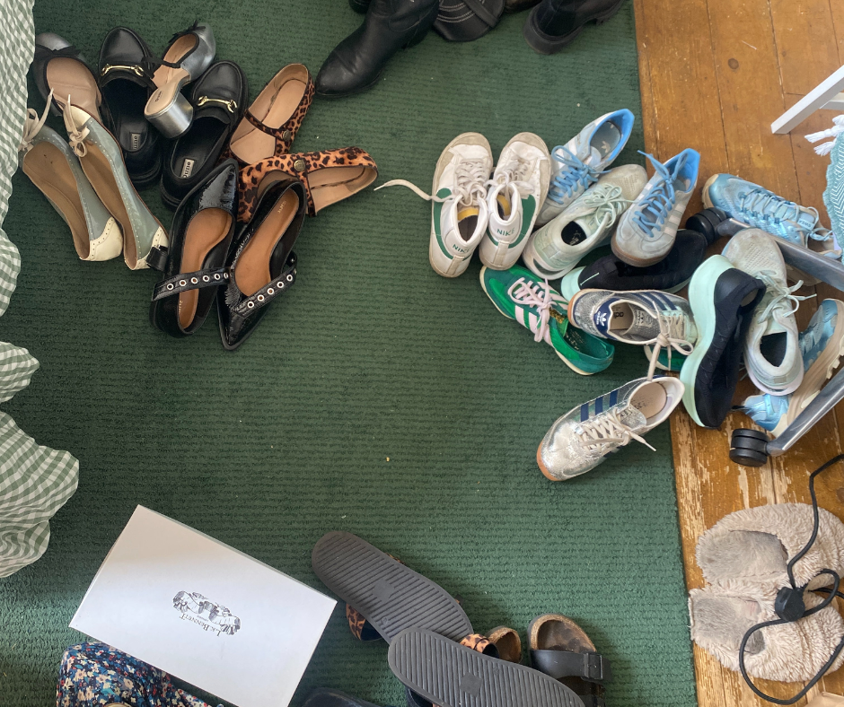 a collection of various shoes arranged on a carpet and wooden floor