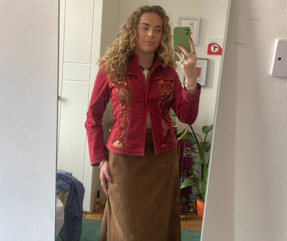 a person wearing a stylish red jacket with floral patterns and a brown skirt