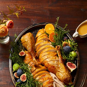sliced thanksgiving turkey on a platter with figs and herbs