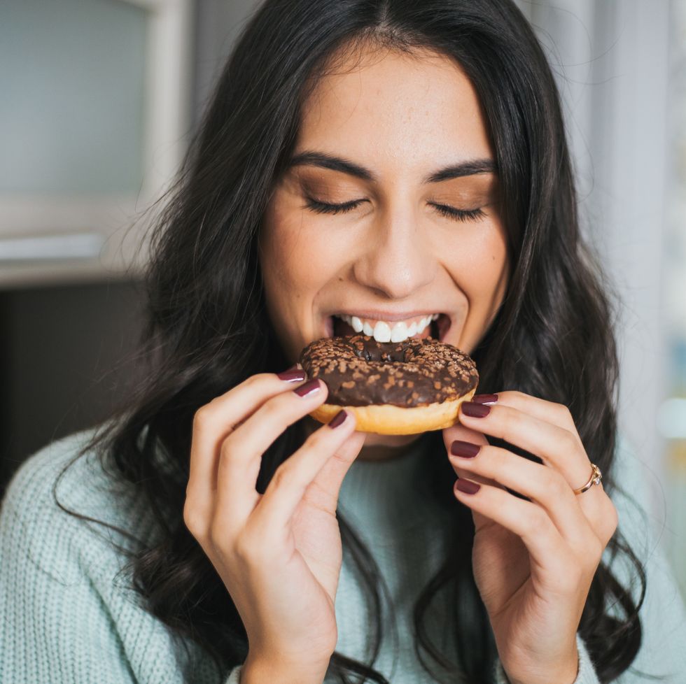 a young woman eats a donut