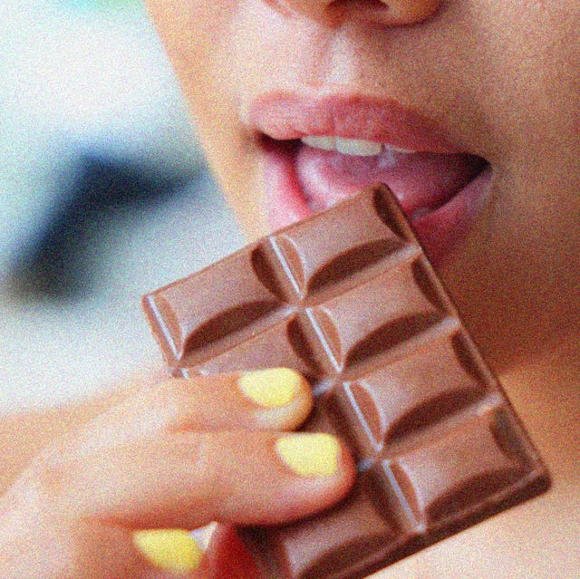 a young woman eating a bar of chocolate