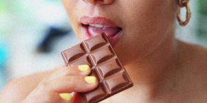 a young woman eating a bar of chocolate