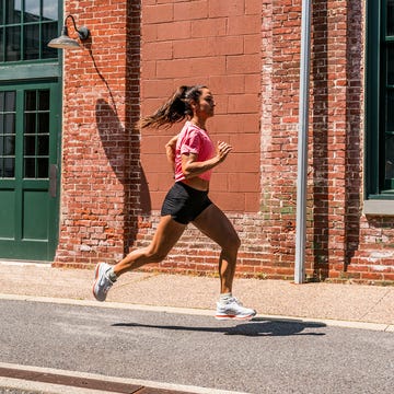 person jogging past a brick building person jogging past a brick building