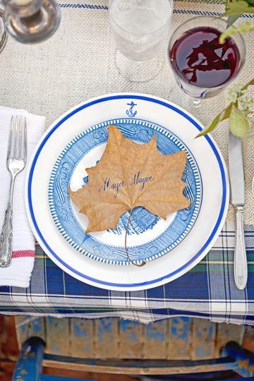 example of how to set a table for an informal meal with blue and white dinnerware and a fall leaf used as placecard