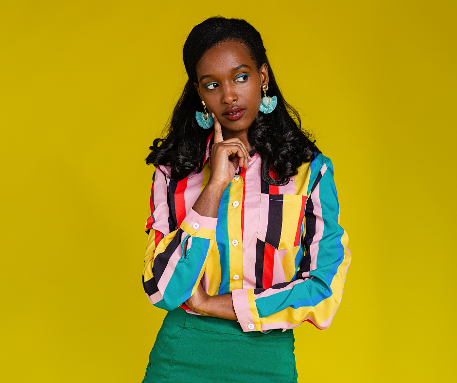 portrait of a person in a colorful striped shirt against a yellow background