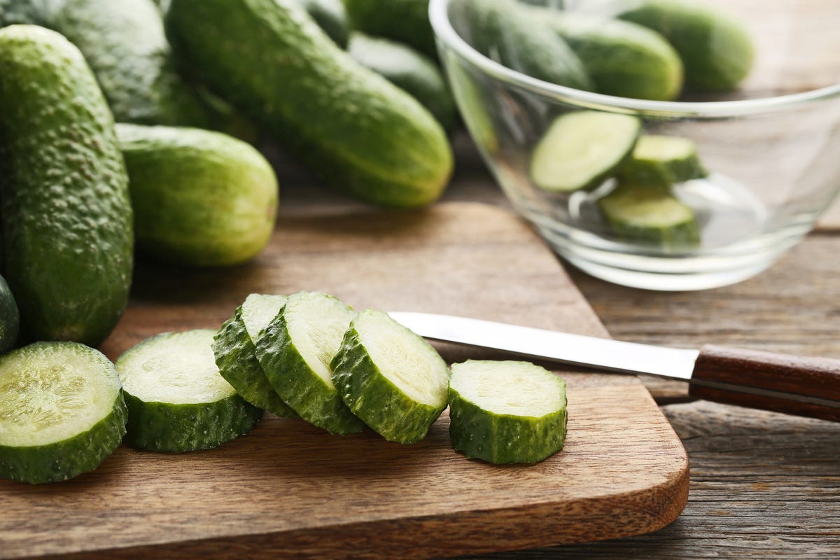 Two fresh green mini cucumbers and sliced half with three slices