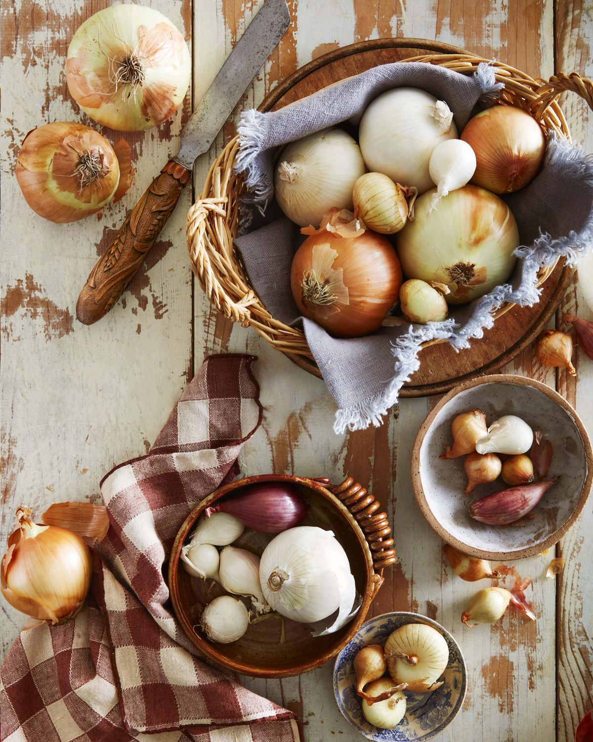 assortment of onions in baskets and bowls