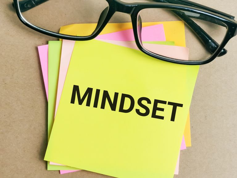 the word mindset written on a bright yellow sticky note
