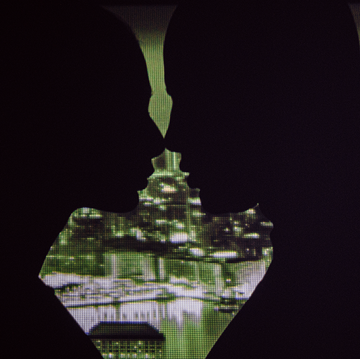 a shadowy couple kissing with a nighttime cityscape in the background