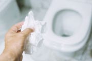 person throwing toilet paper in toilet
