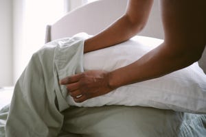 how to wash pillow, close up of unrecognizable woman putting pillow into freshly laundered pillowcase