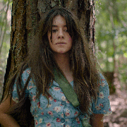 screenshot from where the crawdads sing movie where girl is standing afraid against a tree