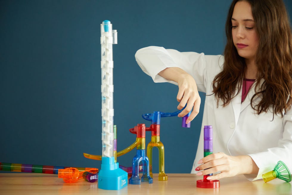 a good housekeeping institute lab expert checks out the individual pieces of a motorized marble run toy