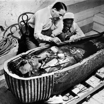 a couple of men working on a sarcophagus of king tut