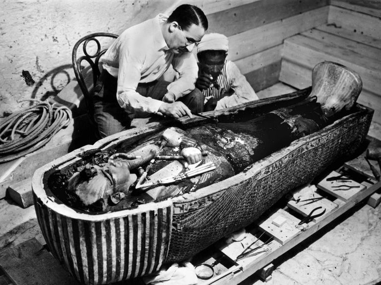 a couple of men working on a sarcophagus of king tut