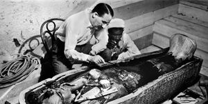a couple of men working on a sarcophagus of king tut