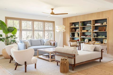 sitting room, library bookcase, white chaise lounge with wooden arms, blue sofa couch, white lounge chairs