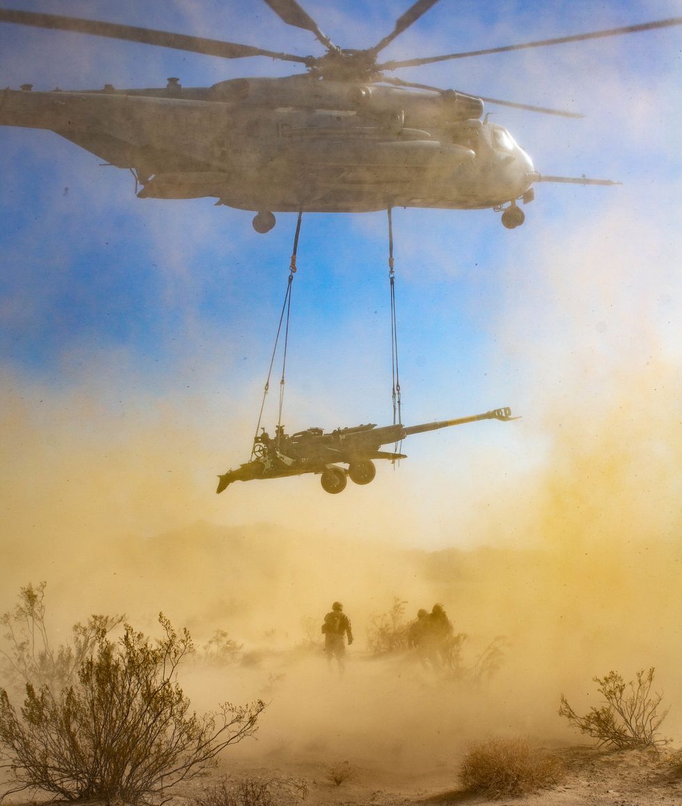 a us marine corps ch 53 super stallion from marine heavy helicopter squadron 464, 2nd marine aircraft wing, ii marine expeditionary force, lifts an m777 howitzer during integrated training exercise 3 22 on marine corps air ground combat center twentynine palms, california, april 11, 2022 it teaches the tactical application of combined arms maneuver, offensive and defensive operations during combat us marine corps photo by cpl kevin n seidensticker