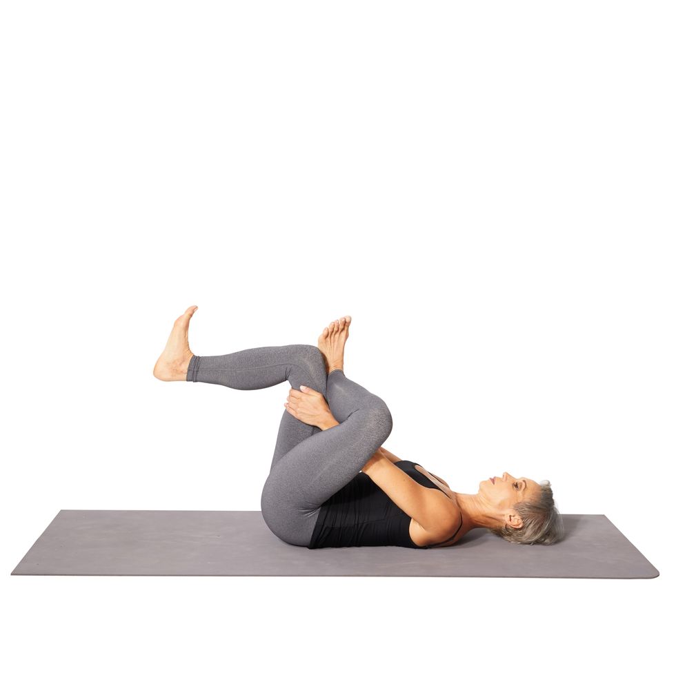 woman doing a figure 4 stretch on the floor