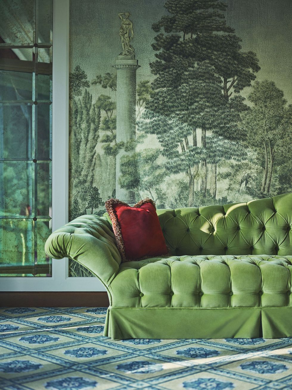 a green couch with a painting on the wall
