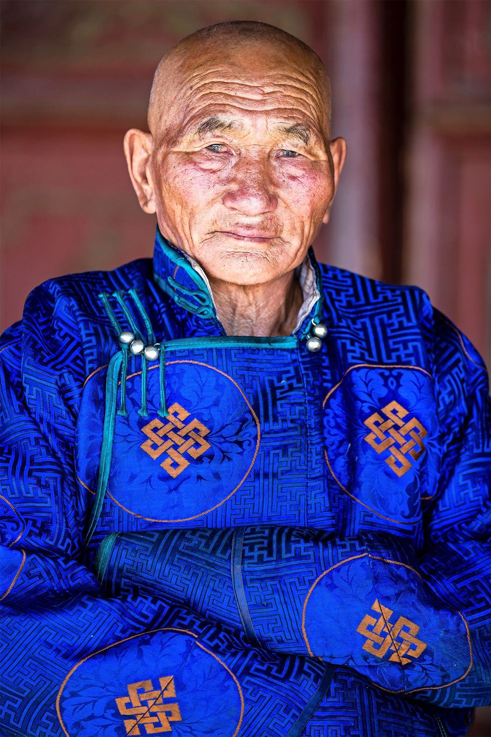 Een bezoeker van het klooster in traditionele Mongoolse jas De jas wordt zowel door mannen als vrouwen gedragen en biedt bescherming tegen de vrieskou