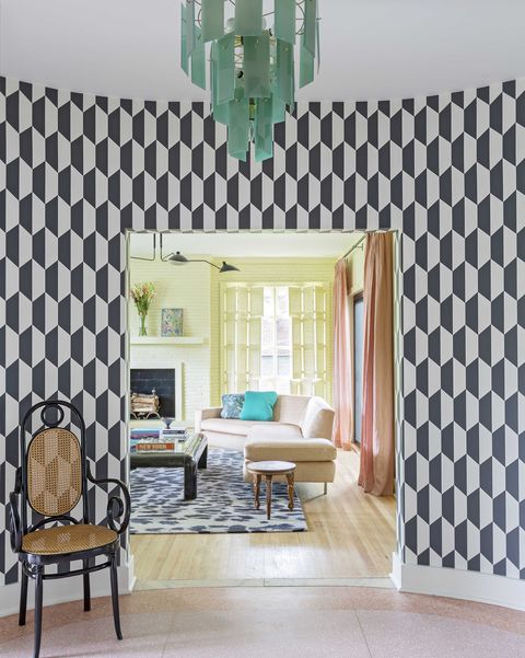 entryway into house, black and white geometric wallpaper, black and brown chair