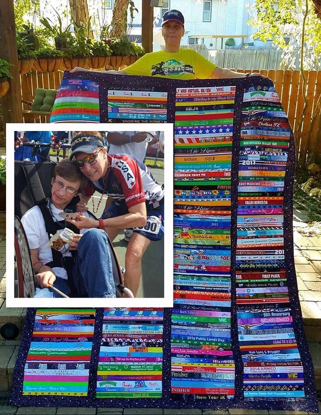 linda sunny fox holding a quilt made with the race bibs and posed with a friend in the disabled community