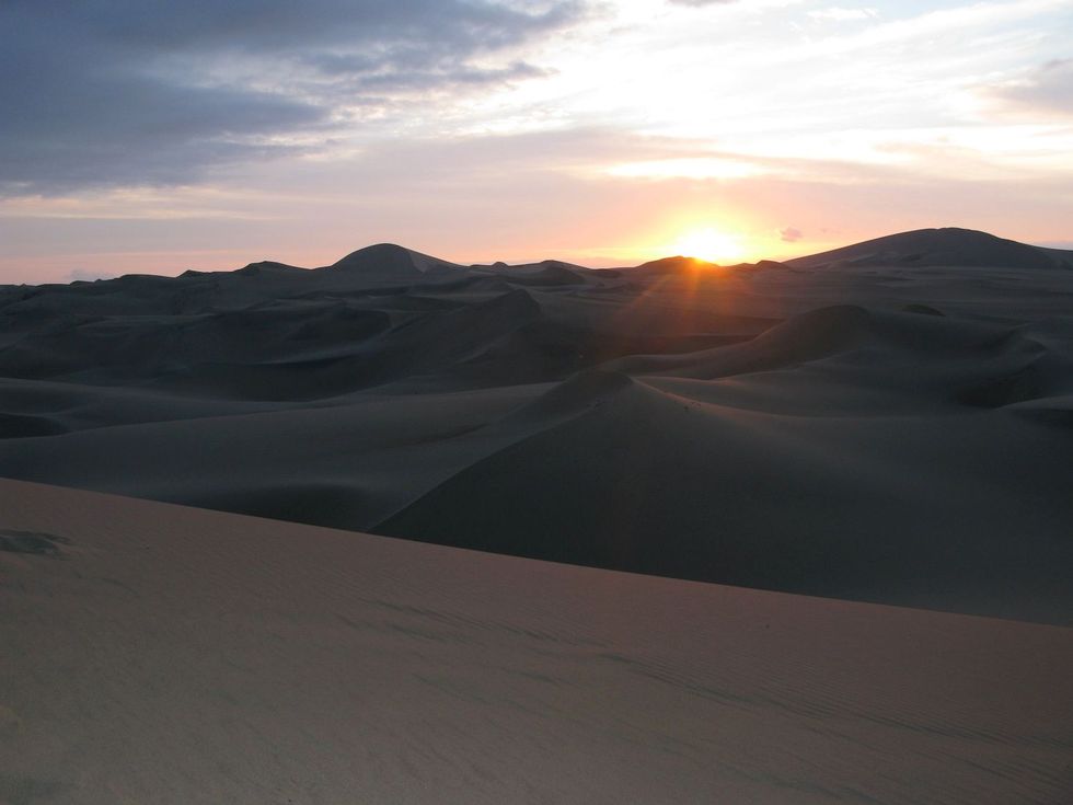 Zonsondergang vanaf een van de zandduinen in de woestijn rondom Huacachina