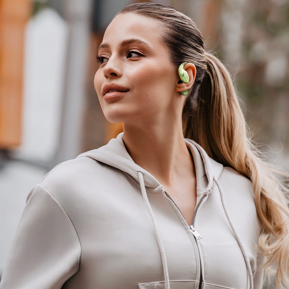 person wearing wireless earbuds and a zipup hoodie