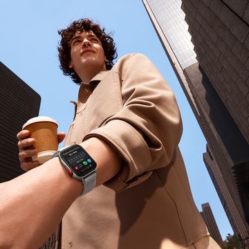 a man wearing a smartwatch, holding a cup of coffee