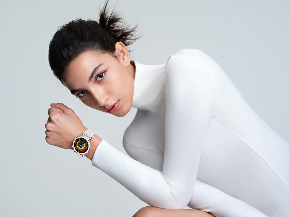 a woman wearing a sporty white mock neck top and a smart watch