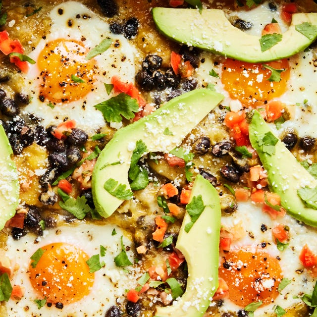 Huevos Rancheros Casserole baked casserole with baked eggs, black beans, avocado slices, and tomato chunks on top of tortillas