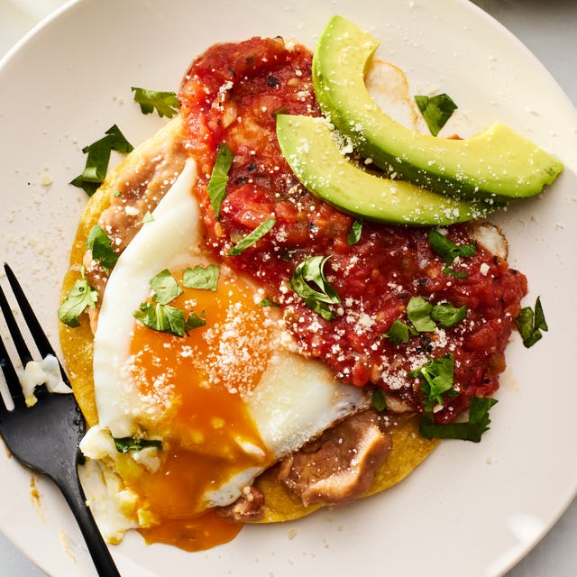 huevos rancheros topped with avocado, cotija and cilantro
