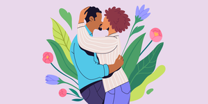 couple hugging with flowers behind them