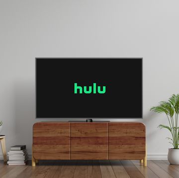 tv with hulu logo on screen on top of cabinet in between plants