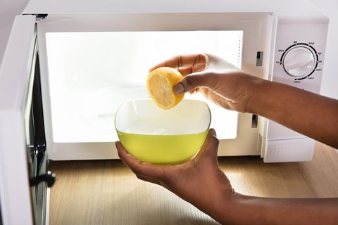 Human Hand Putting Sliced Lemon In Bowl