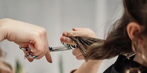 human hands hair cut using a scissors lock of hair