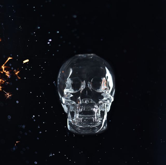human skull with sparks over black background